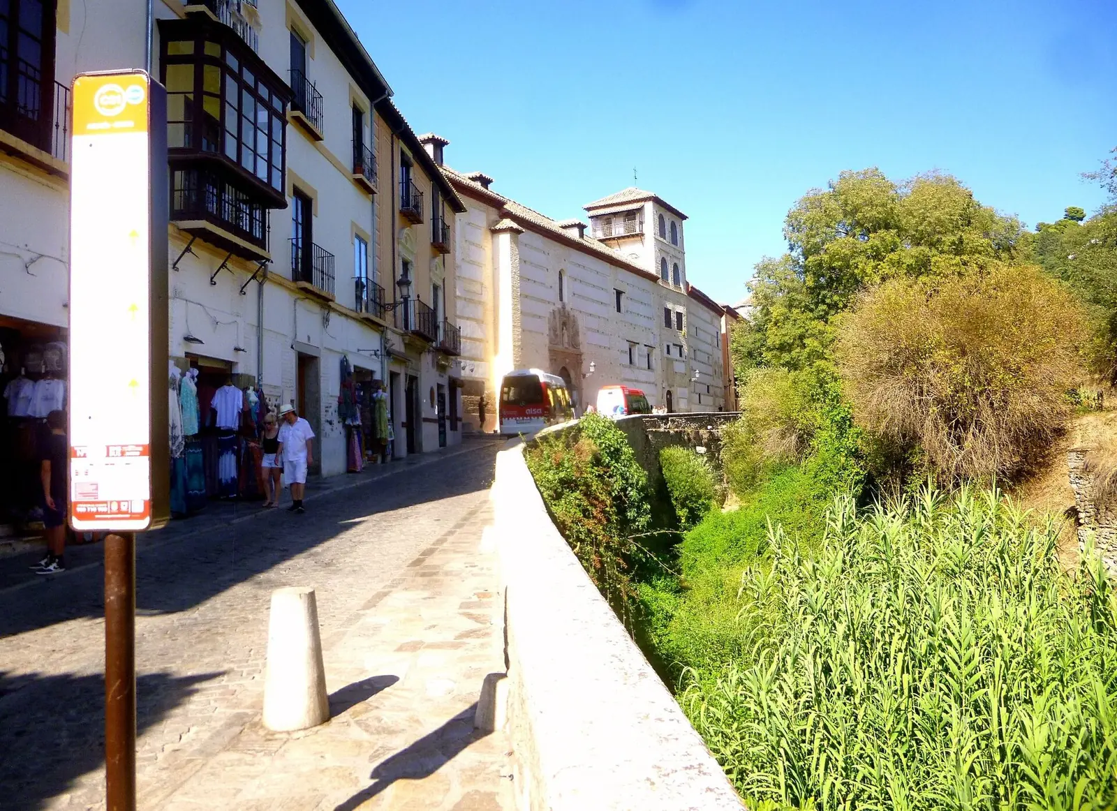 Η Carrera del Darro στη Γρανάδα, ένας λιθόστρωτος δρόμος δίπλα στην όχθη του ποταμού με παλιά σπίτια στα αριστερά και πράσινα καλάμια στα δεξιά